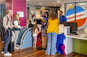 Familie checkt an der Rezeption der Jugendherberge Mainz ein und freut sich auf ihren Familienurlaub.